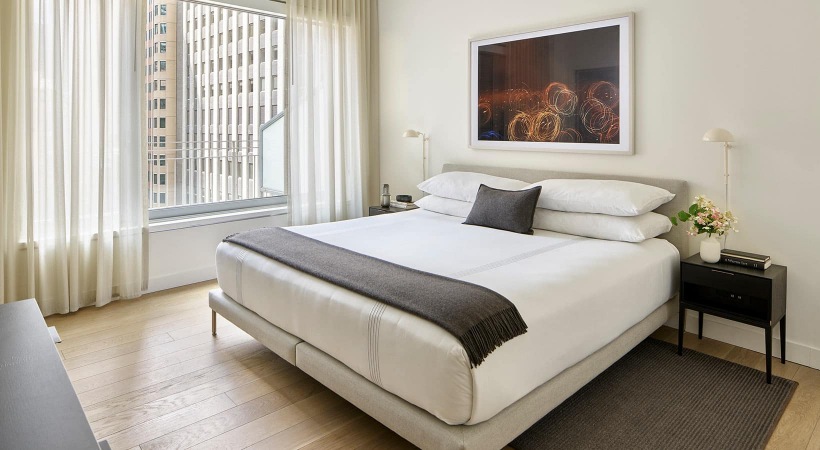 spacious bedroom with large windows that allow ample, natural lighting into room